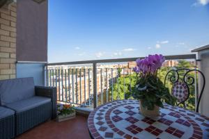 una mesa de patio con un jarrón de flores en el balcón en Rogiual, en Roma