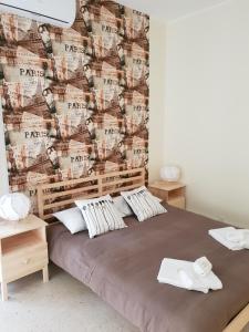 a bedroom with a large bed with a wall with aadobeadobeadobeadobeadobe w obiekcie Perla Sicula w Katanii
