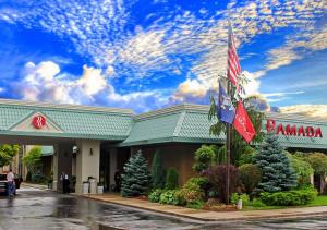 un edificio con banderas americanas delante de él en Ramada by Wyndham Alpena, en Alpena