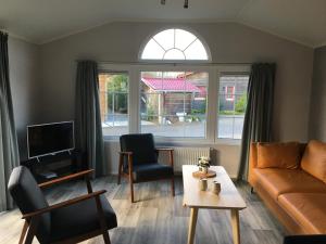 a living room with a couch and a table at De Roos chalet 174 in Sint Annaland