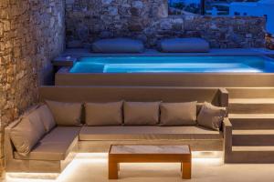 a hot tub in a room with a couch and a table at Villa ANAIS 2 MYKONOS in Elia Beach