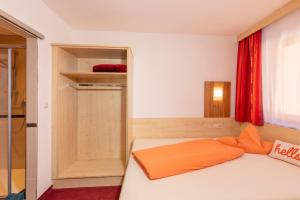 1 dormitorio con cama y cortina roja en Gästehaus Berghof Schöpf, en Längenfeld