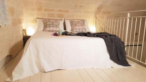 a white bed with a blanket on it in a room at Twins Apartments in Bari