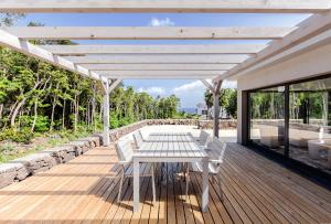 a white table and chairs on a wooden deck at Pico Dreams - Sportfish in São Roque do Pico