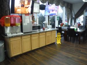 a kitchen with a counter with a microwave and a table at Budgetel Inn & Suites Hotel in Grand Rapids