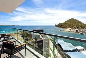 a balcony with chairs and a view of the ocean at Breathless Cabo San Lucas - Adults Only in Cabo San Lucas