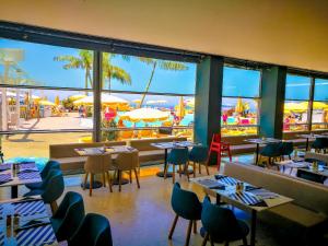 a restaurant with tables and chairs and a view of the beach at Apartamentos Monteparaiso in Puerto Rico de Gran Canaria