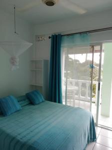 a bedroom with a blue bed and a balcony at Apartment Espoir in Castries