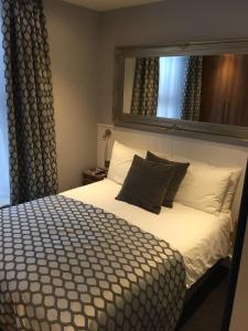 a bedroom with a bed with a mirror above it at Carlton Hotel in Ilfracombe