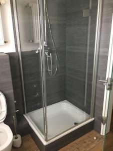 a shower with a glass enclosure in a bathroom at Ferienwohnung Eport in Bendorf
