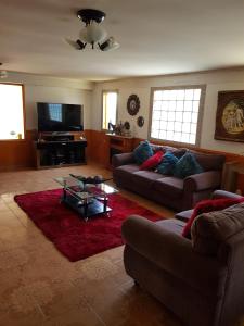 una sala de estar con 2 sofás y una alfombra roja en Residencial mi Casa en Olmué