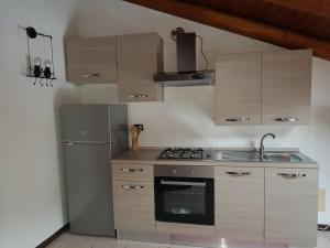 a kitchen with a stove and a refrigerator at Rouge et Noir in Saint Vincent