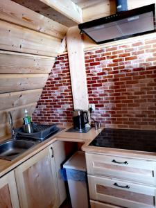 a kitchen with a sink and a brick wall at Pokoje goscinne u Jozka in Chochołów