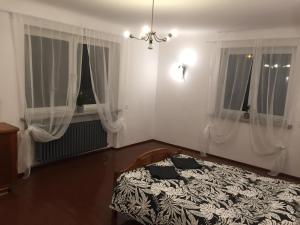 sypialnia z łóżkiem i dwoma oknami w obiekcie Dom Warszawa/Legionowo w mieście Legionowo