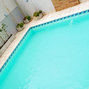 una piscina con agua azul y macetas en Brizo Salta en Salta