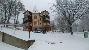 un grand bâtiment dans la neige devant dans l'établissement Karkonoska 41, à Karpacz