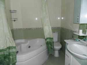 uma casa de banho com uma banheira, um WC e um lavatório. em Bank Respublika Apartment em Baku