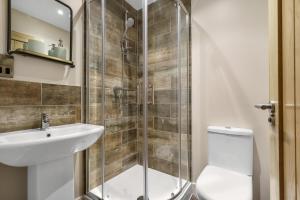 a bathroom with a shower and a toilet and a sink at Executive Apartments in Andover +16 photos