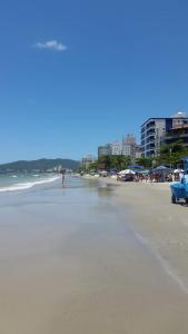 una playa con un coche azul estacionado en la arena en Lindo apartamento super completo em Meia Praia, 100 metros do mar e 10 quadras do centro, en Itapema