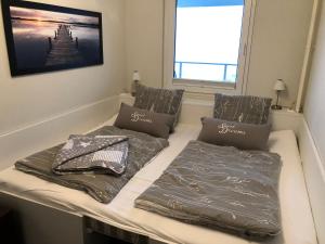 a bed in a room with two pillows on it at Meerblickappartement mit Ladesäule in Glücksburg