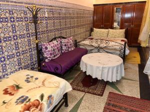 Sala de estar con 2 camas y mesa en Dar Hlimi, en Fez