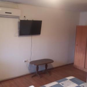 a room with a table and a flat screen tv on a wall at Hotel Nogal in Constitución