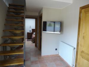 una camera con scala e TV a parete di Casa Rural Cal Xico ad Adrall
