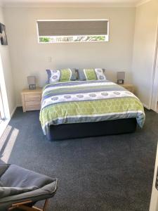 a bedroom with a large bed and a window at Otaki Beachfront Getaway in Otaki Beach