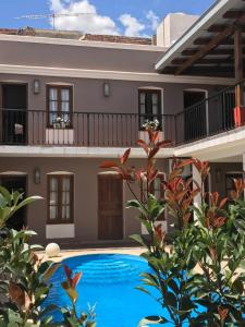 une villa avec une piscine en face d'une maison dans l'établissement Hotel Plaza Cafayate, à Cafayate