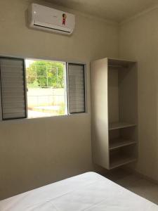 um quarto com uma cama e uma janela em Flat Thermas Olimpia - 300 metros do Thermas dos Laranjais em Olímpia