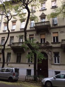 a building with cars parked in front of it at Platanus Guesthouse in Budapest