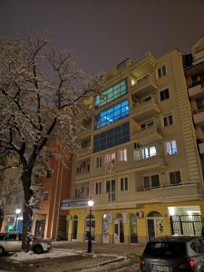 ein Gebäude in der Nacht mit davor geparkt in der Unterkunft Smiley - Subotica Centar in Subotica