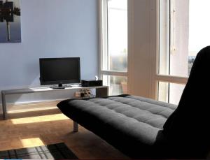 a living room with a couch and a flat screen tv at Escale Quai George V in Le Havre