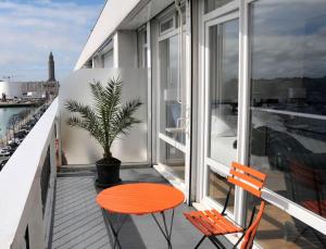 a balcony with a table and two chairs and a plant at Escale Quai George V in Le Havre