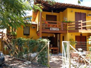 a yellow house with a gate in front of it at Pousada Peixe Espada in Praia do Forte