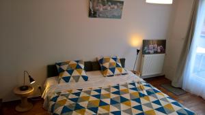 a bedroom with a bed with a checkered blanket at Bambou & Olivier Chambres in Roubaix