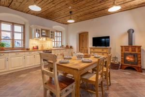 a kitchen with a wooden table and chairs and a fireplace at Statek U Medvěda in Nová Pec