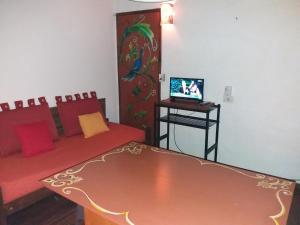 a room with a couch and a table with a tv at Cabañas Alfar Sol y Mar in Mar del Plata