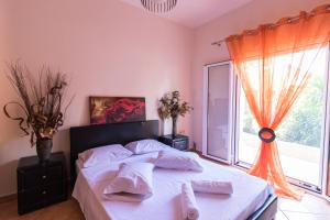 a bedroom with a bed and a large window at Traditional Fishing Village Apartments in Boukari