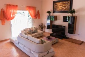 uma sala de estar com 2 sofás e uma televisão de ecrã plano em Traditional Fishing Village Apartments em Boukari