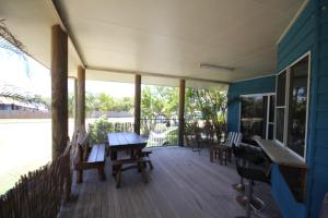 a screened porch with a wooden table and chairs at CASTAWAY BEACH HOUSE- NO Parties - NO Pets in Agnes Water