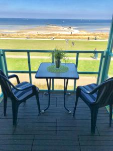 a table and chairs on a balcony with a view of the beach at Steiner Strandappartements Appartement 201 Seeseite in Stein