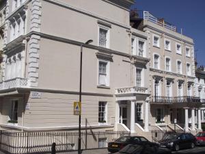 a large white building with cars parked in front of it at Lords Hotel in London