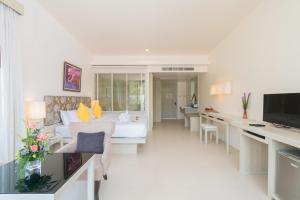 een woonkamer met een witte bank en een tafel bij The Briza Beach Resort, Khao Lak SHA Extra Plus in Khao Lak
