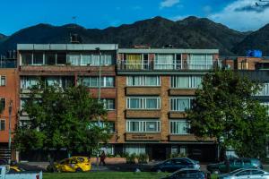 an apartment building with cars parked in a parking lot at Apartamentos Galerías in Bogotá