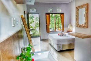 sypialnia z łóżkiem i dużym oknem w obiekcie Canang Gardens w mieście Ubud