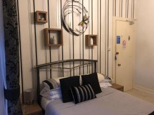 Schlafzimmer mit einem Bett mit schwarzen und weißen Kissen in der Unterkunft The Arrandale Hotel in Ayr