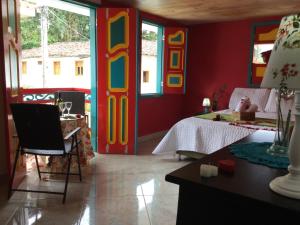 a bedroom with a bed and a room with colorful walls at Casa Pachamama in Salento