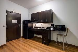 a kitchen with a desk with a microwave and a refrigerator at Motel 6 Poplar Bluff, MO in Poplar Bluff