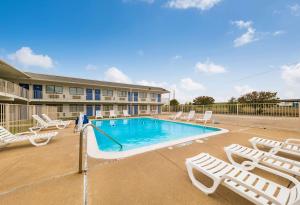 a swimming pool with chaise lounges and lounge chairs at Motel 6-Greenville, TX in Greenville